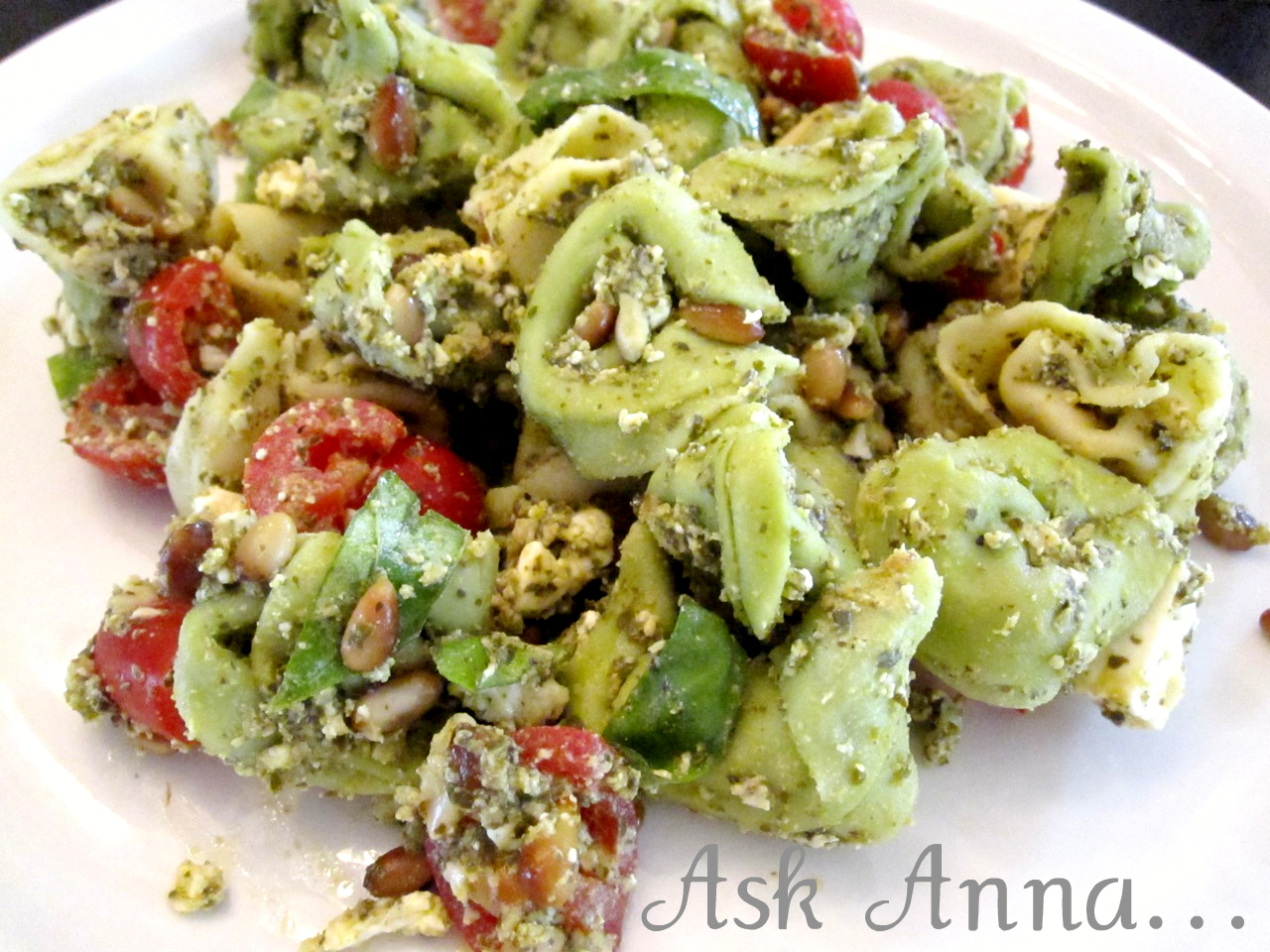 This basil, pesto, tortellini pasta salad is fresh and delicious, the perfect summer dinner or BBQ side dish. The fresh flavors of the basil, pesto and feta are balanced beautifully by the nuttiness of the pine nuts and creamy cheese tortellini. | Ask Anna