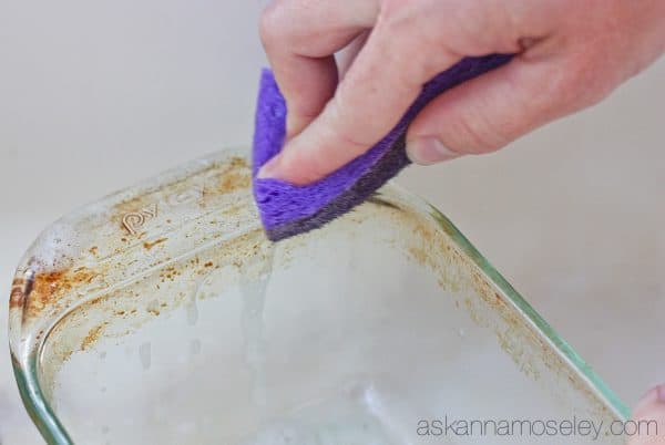 This is a really simple tip for how to clean baked-on grease off pots, pans & baking dishes. You will be AMAZED at how easy it is to get tough grease off with just a sponge and a little dish soap | Ask Anna