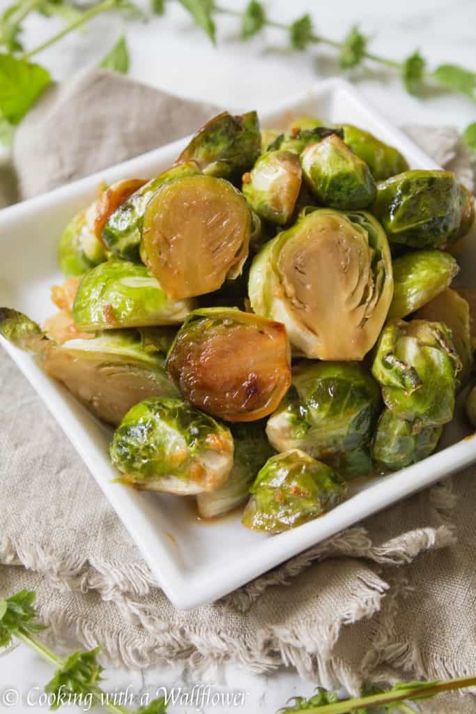 Brussels sprouts tossed in honey, sesame oil, and soy sauce then roasted until slightly charred. These roasted honey sesame brussels sprouts are delicious and a great side dish. | Cooking With a Wallflower