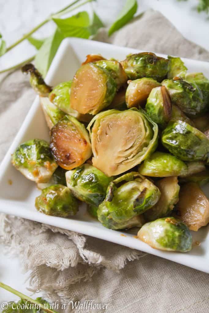 Brussels sprouts tossed in honey, sesame oil, and soy sauce then roasted until slightly charred. These roasted honey sesame brussels sprouts are delicious and a great side dish. | Cooking With a Wallflower