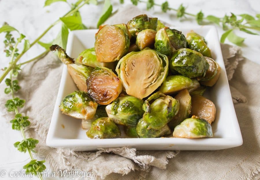 Brussels sprouts tossed in honey, sesame oil, and soy sauce then roasted until slightly charred. These roasted honey sesame brussels sprouts are delicious and a great side dish. | Cooking With a Wallflower