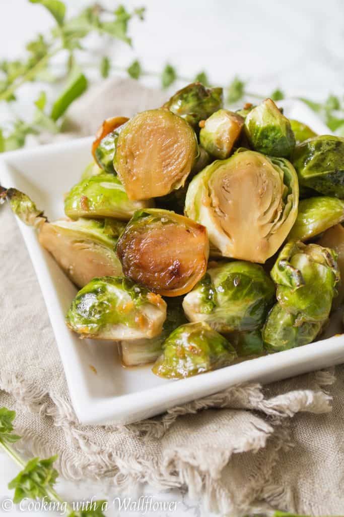 Brussels sprouts tossed in honey, sesame oil, and soy sauce then roasted until slightly charred. These roasted honey sesame brussels sprouts are delicious and a great side dish. | Cooking With a Wallflower