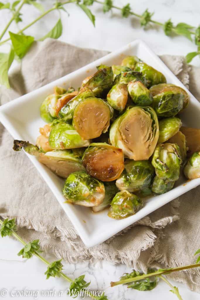 Brussels sprouts tossed in honey, sesame oil, and soy sauce then roasted until slightly charred. These roasted honey sesame brussels sprouts are delicious and a great side dish. | Cooking With a Wallflower