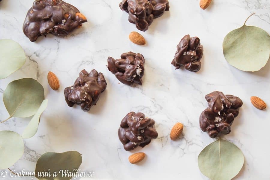 Roasted almonds coated with semi sweet chocolate then topped with a pinch of vanilla salt. These chocolate covered almond clusters are so simple to make and perfect for gifting. | Cooking With a Wallflower