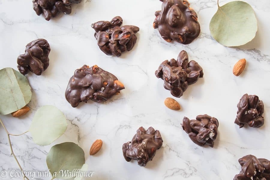 Roasted almonds coated with semi sweet chocolate then topped with a pinch of vanilla salt. These chocolate covered almond clusters are so simple to make and perfect for gifting. | Cooking With a Wallflower