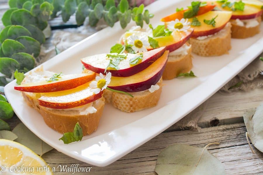 Crispy bread topped with fresh peaches, creamy burrata, mint and a sweet, tangy, honey, lemon dressing. Super fresh, easy to make, and pleasantly delicious, this peach burrata toast is the perfect appetizer for summer guests. | Cooking with a Wildflower