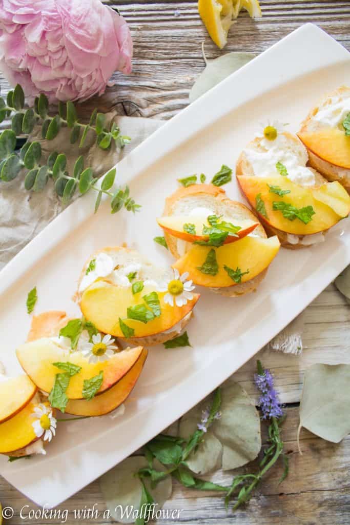 Crispy bread topped with fresh peaches, creamy burrata, mint and a sweet, tangy, honey, lemon dressing. Super fresh, easy to make, and pleasantly delicious, this peach burrata toast is the perfect appetizer for summer guests. | Cooking with a Wildflower