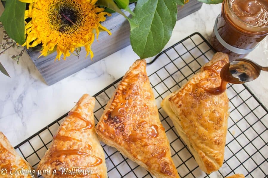 Puff pastries filled with cinnamon apples and drizzled with salted caramel, these salted caramel apple turnovers are simple to make and delicious. | Cooking with a Wallflower