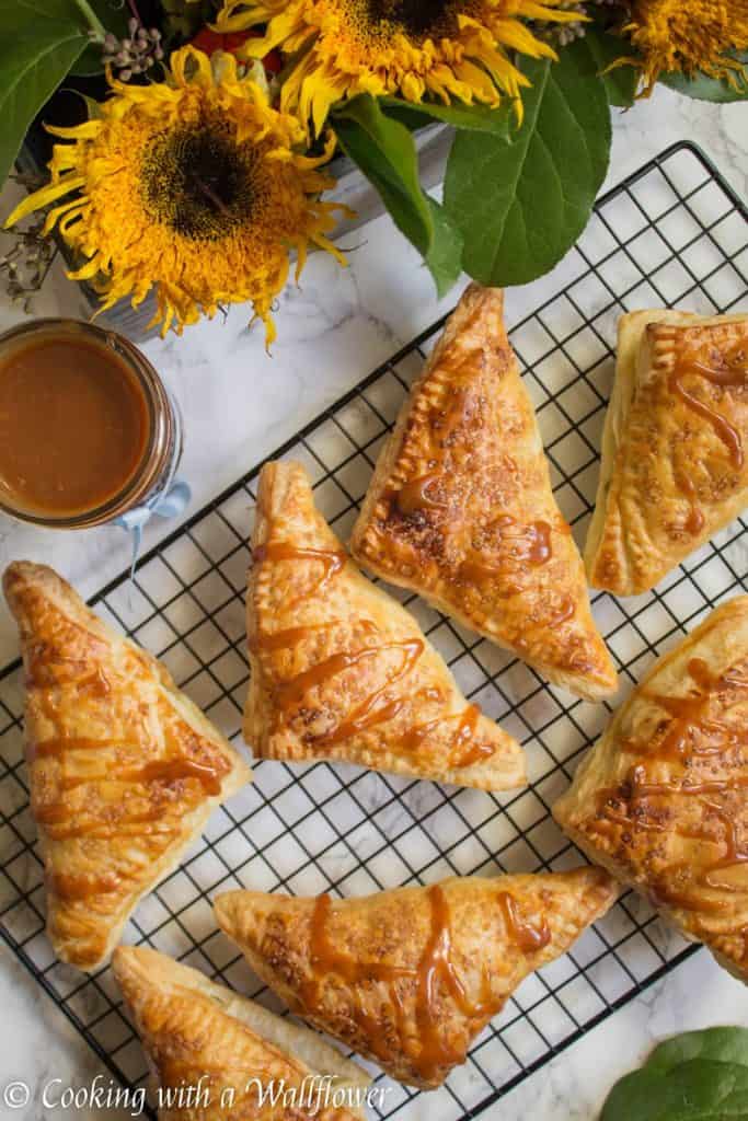 Puff pastries filled with cinnamon apples and drizzled with salted caramel, these salted caramel apple turnovers are simple to make and delicious. | Cooking with a Wallflower