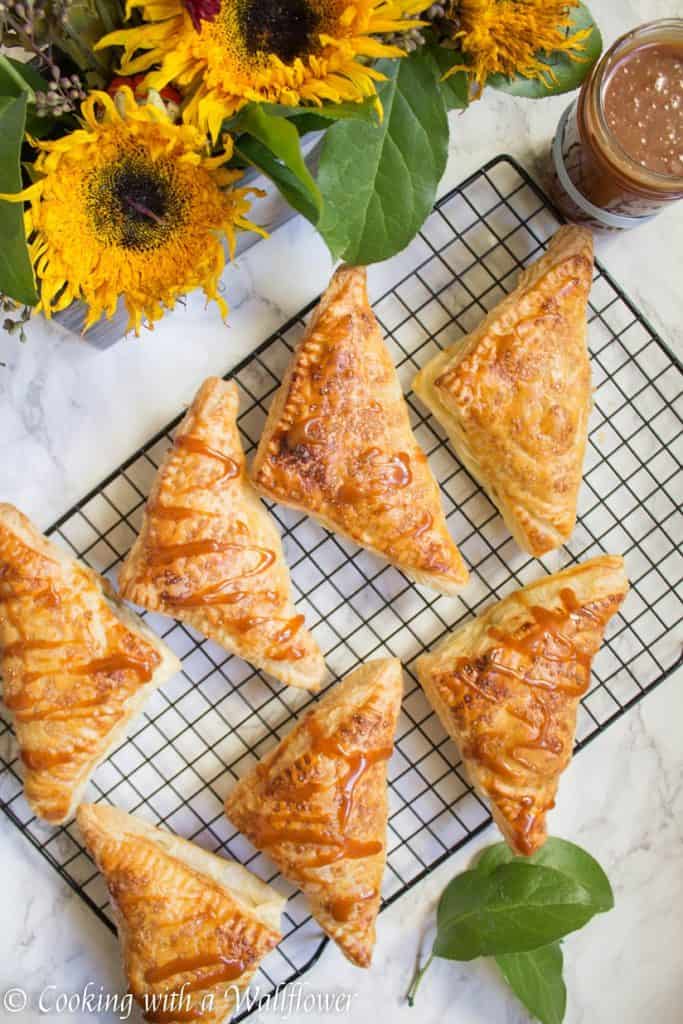 Puff pastries filled with cinnamon apples and drizzled with salted caramel, these salted caramel apple turnovers are simple to make and delicious. | Cooking with a Wallflower