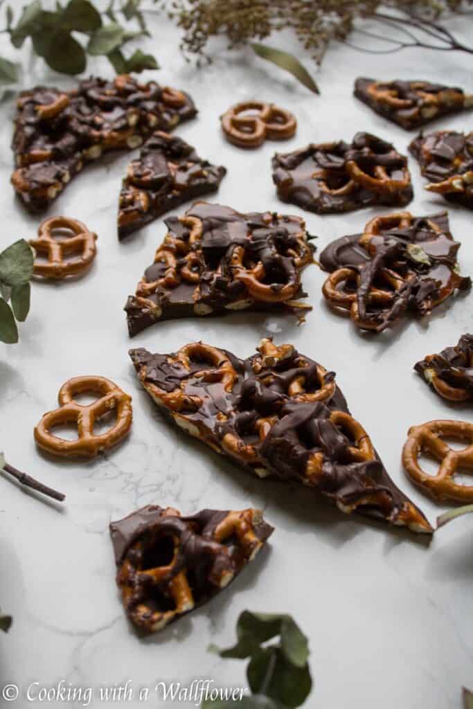 Semi sweet chocolate bark piled with mini pretzels and drizzled with salted caramel. This salted caramel pretzel bark is simple to make and the perfect sweet and savory snack. | Cooking with a Wallflower