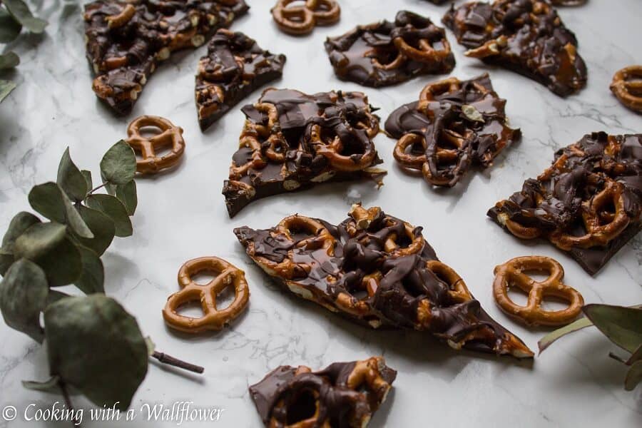 Semi sweet chocolate bark piled with mini pretzels and drizzled with salted caramel. This salted caramel pretzel bark is simple to make and the perfect sweet and savory snack. | Cooking with a Wallflower