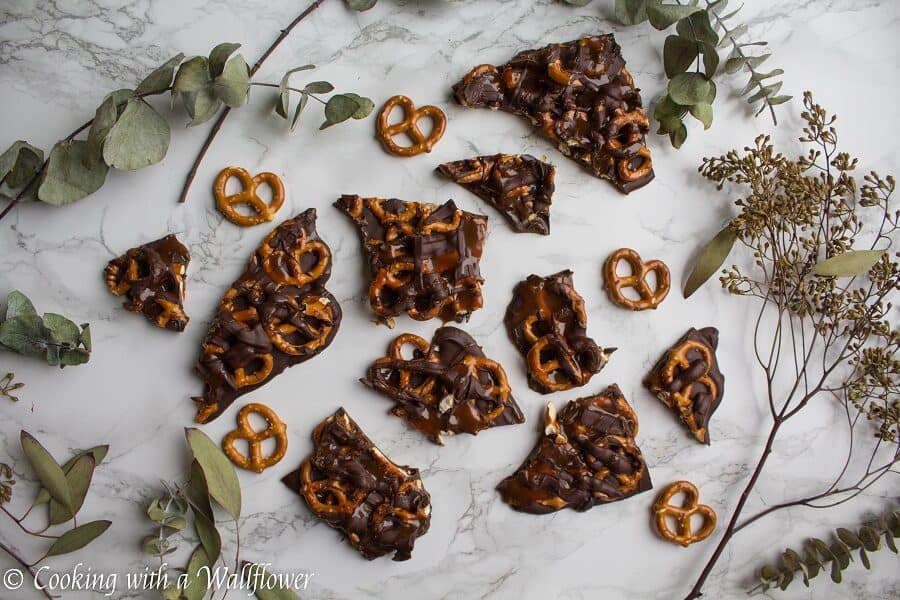 Semi sweet chocolate bark piled with mini pretzels and drizzled with salted caramel. This salted caramel pretzel bark is simple to make and the perfect sweet and savory snack. | Cooking with a Wallflower