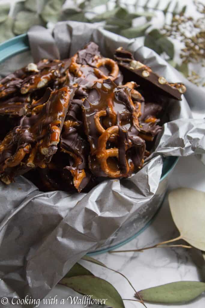 Semi sweet chocolate bark piled with mini pretzels and drizzled with salted caramel. This salted caramel pretzel bark is simple to make and the perfect sweet and savory snack. | Cooking with a Wallflower