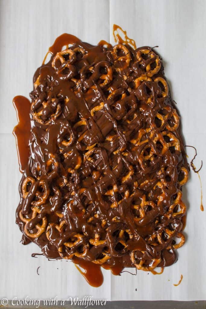 Semi sweet chocolate bark piled with mini pretzels and drizzled with salted caramel. This salted caramel pretzel bark is simple to make and the perfect sweet and savory snack. | Cooking with a Wallflower