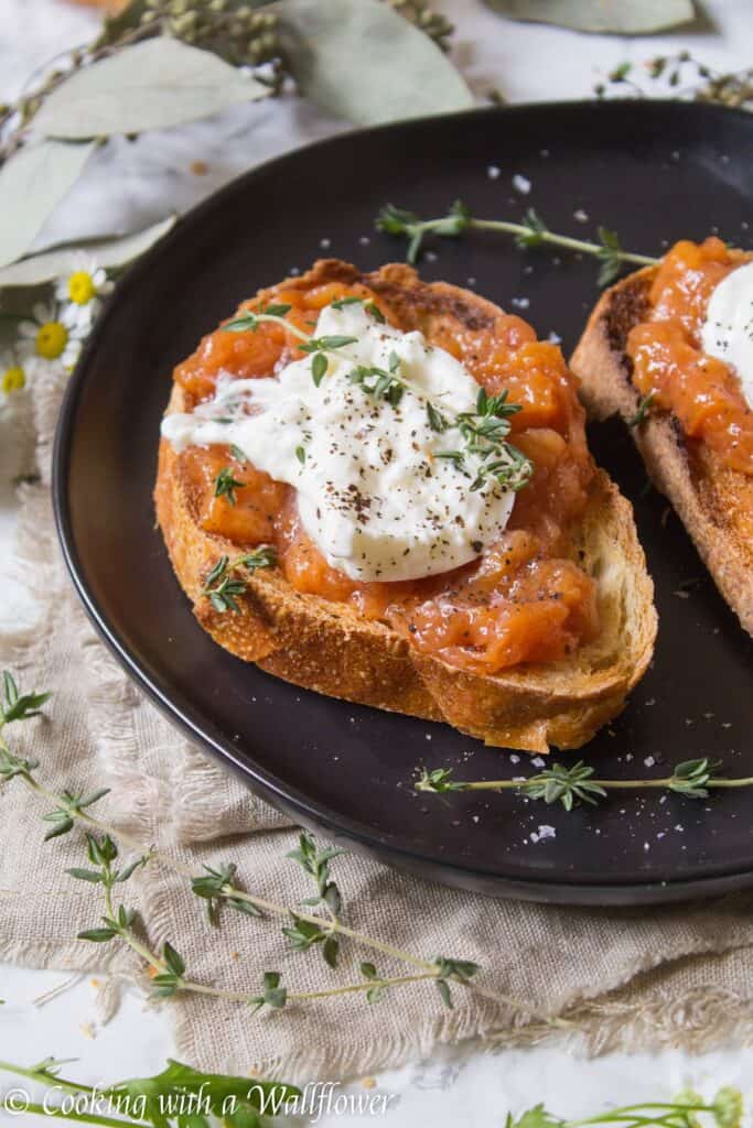 Toast topped with sweet peach jam, creamy burrata, thyme, salt and pepper. This Peach Jam Burrata Toast is delicious and perfect for breakfast or a late summer snack. | Cooking with a Wallflower