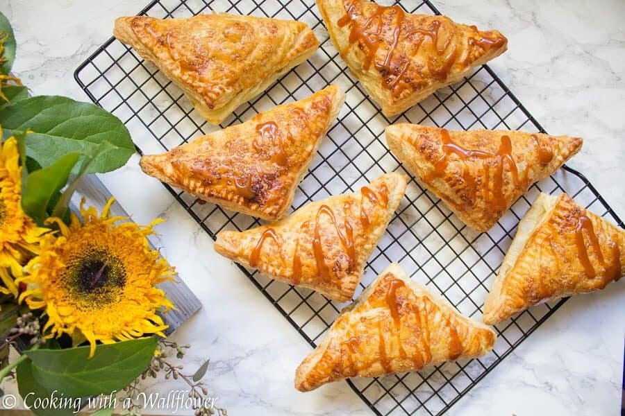 Puff pastries filled with cinnamon apples and drizzled with salted caramel, these salted caramel apple turnovers are simple to make and delicious. | Cooking with a Wallflower